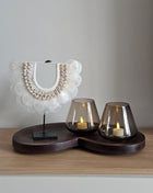 Woonaccessoire Set Walnut Cozy met een witte schelpenketting en twee taupekleurige Tasman waxinelichthouders op een walnoot dienblad.