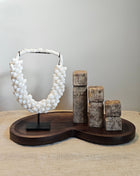 Woonaccessoire Set Walnut Stone met drie abstracte stenen figuren en een witte schelpenketting op een walnoothouten Villeta dienblad.
