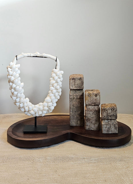 Woonaccessoire Set Walnut Stone met drie abstracte stenen figuren en een witte schelpenketting op een walnoothouten Villeta dienblad.